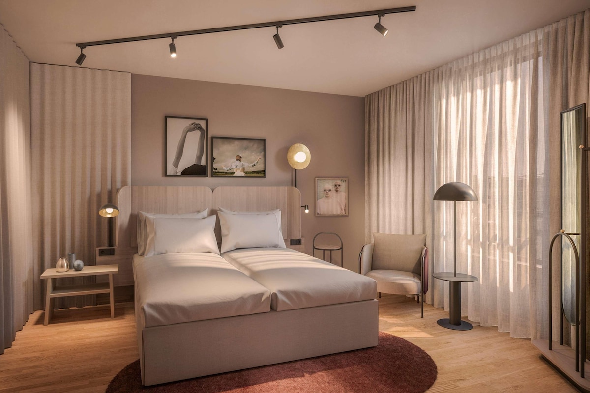 Un dormitorio moderno con una cama grande, mesitas de noche, una silla y una lámpara de pie.