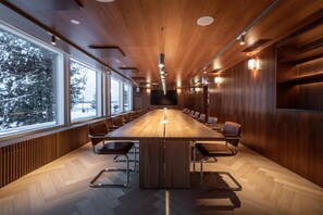 A conference room with a long table, chairs, and a large window overlooking a snowy landscape. - Scandic Pohjanhovi (Rovaniemi)