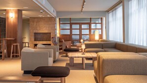 A modern living room with sofas, a coffee table, and a fireplace. - Scandic Pohjanhovi (Rovaniemi)