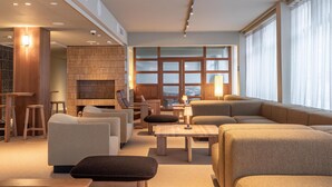 A modern living room with sofas, a coffee table, and a fireplace. - Scandic Pohjanhovi (Rovaniemi)