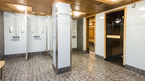 A public restroom with tiled floors, multiple sinks, and a wooden door. - Scandic Pohjanhovi (Rovaniemi)