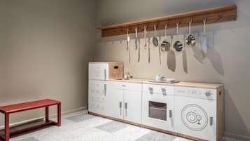 A compact kitchen with a wooden countertop, a built-in oven, and a hanging pot rack.
