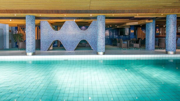 A swimming pool with a tiled floor and a decorative structure with a geometric design. - Scandic Pohjanhovi (Rovaniemi)