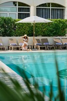 Una piscina al aire libre de temporada, sombrillas