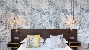 Een hotelkamer met een bed, twee nachtkastjes en een hoofdeinde.