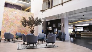 Un vestíbulo moderno con zonas de estar, una recepción y un amplio panel decorativo.