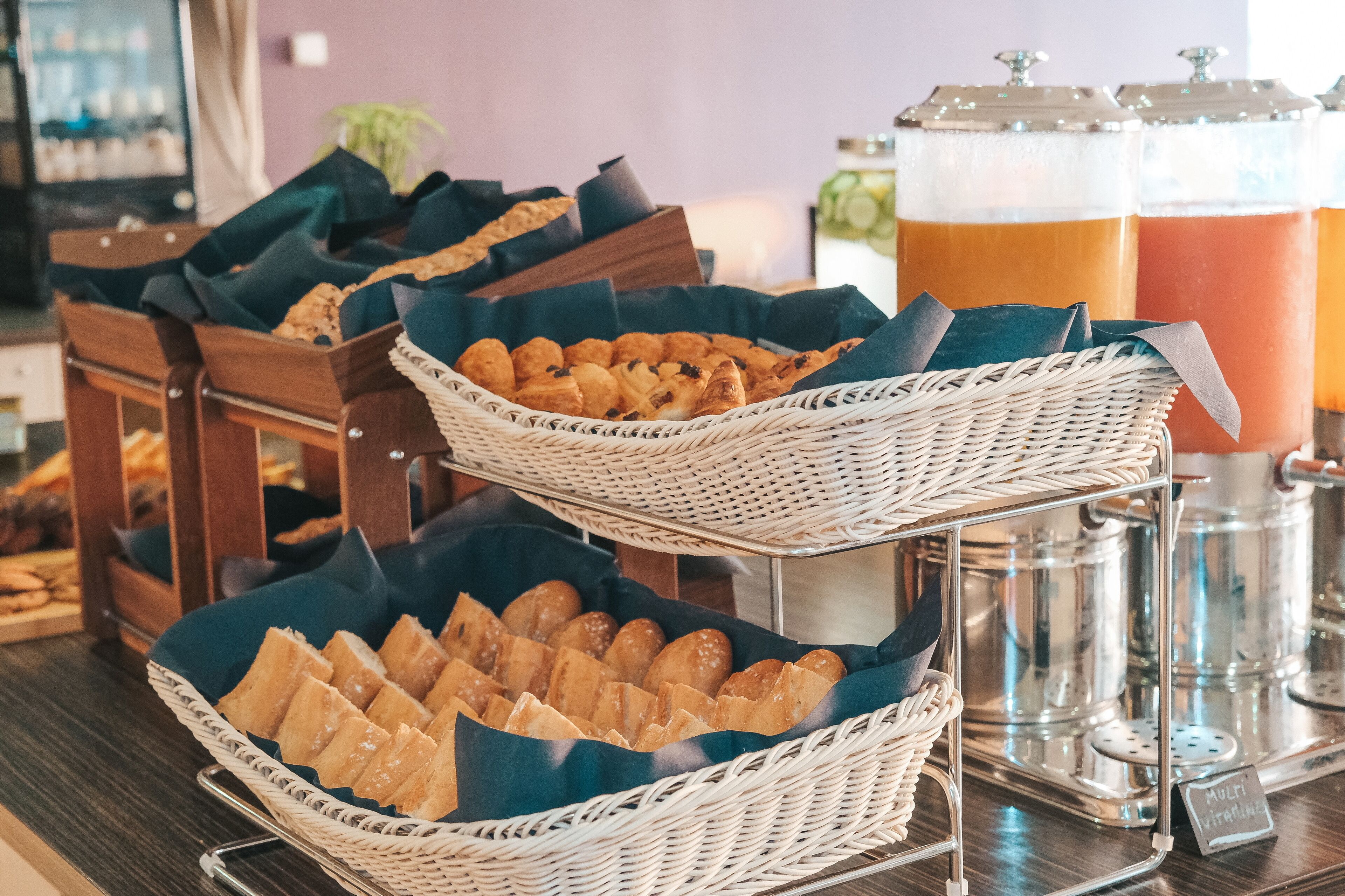 Un bufé de desayuno con dispensadores de pan y zumo.