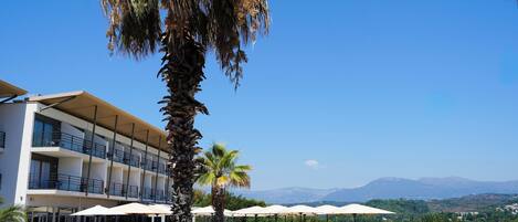 A resort with a pool, outdoor seating, and a view of mountains.