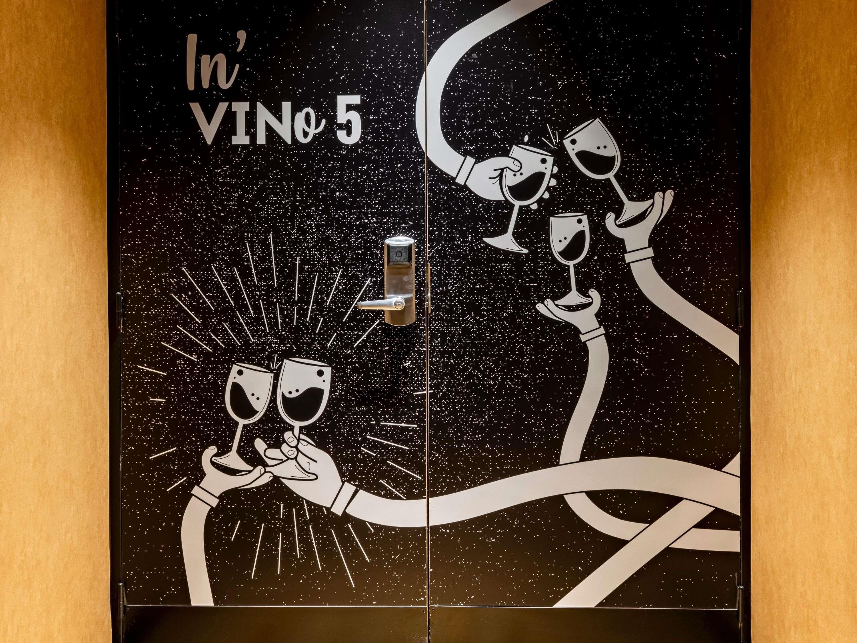 A door with a space-themed design, including stars and a hand holding a wine glass.