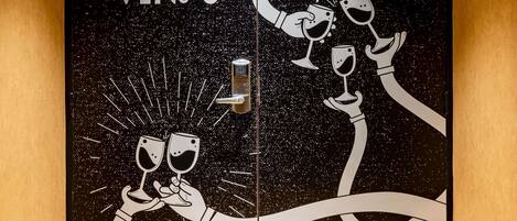A door with a space-themed design, including stars and a hand holding a wine glass.