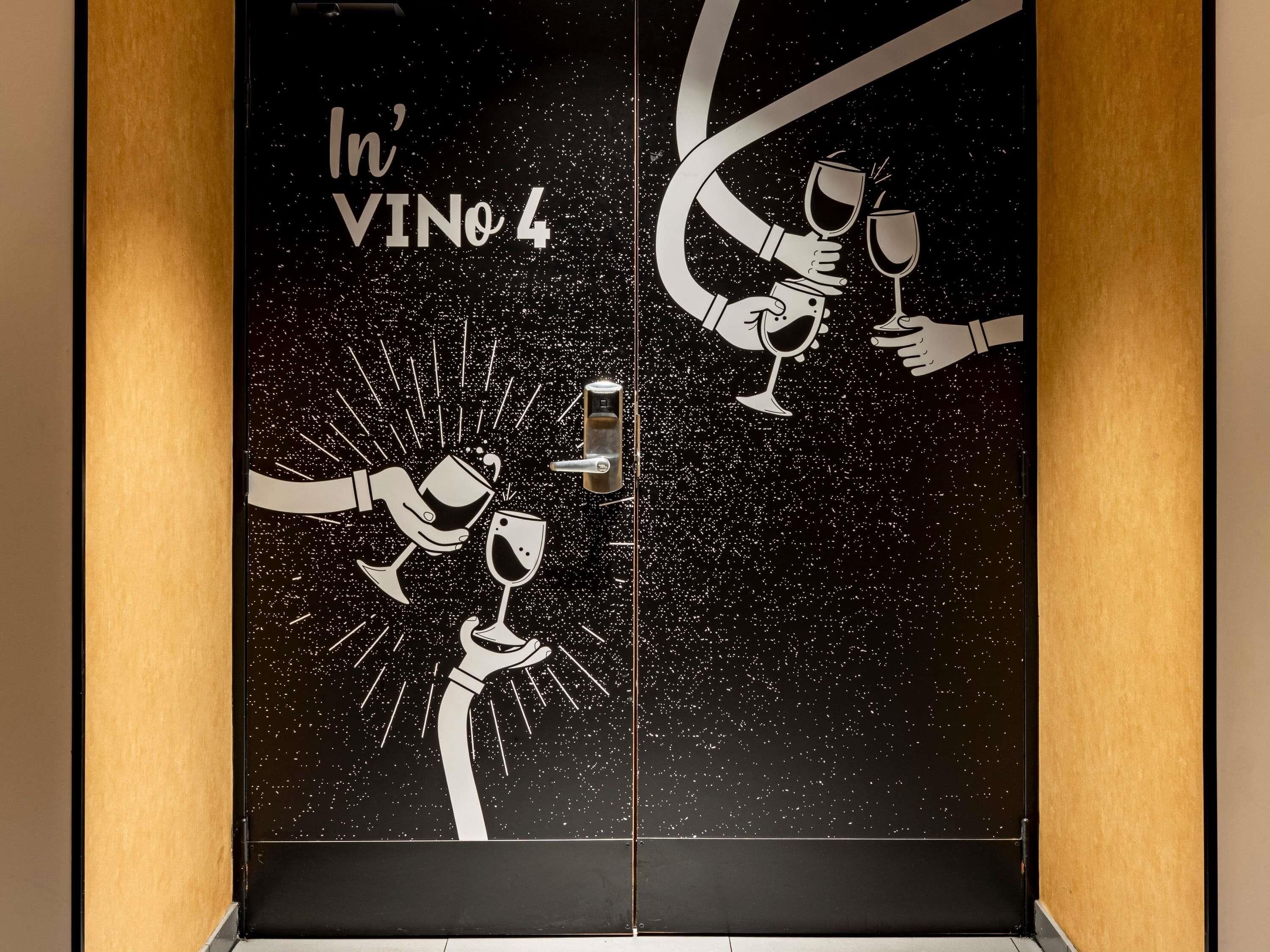 A door with a space-themed design featuring hands holding wine glasses and the text 'In' VINO 4'.