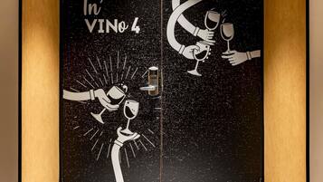 A door with a space-themed design featuring hands holding wine glasses and the text 'In' VINO 4'.