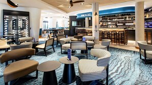Un área de estar moderna con asientos, un bar y una sección de vinos.