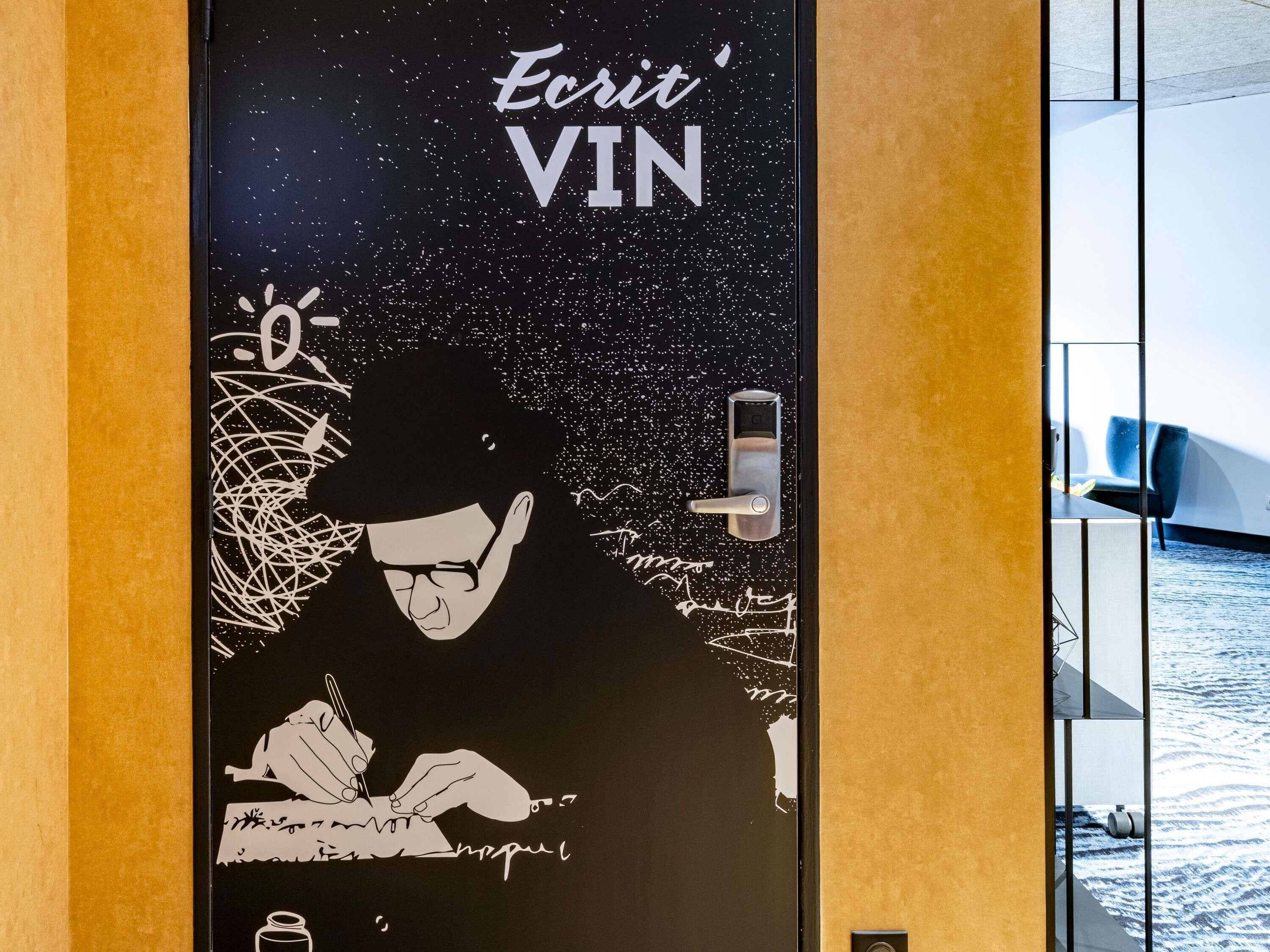 Una puerta con diseño temático del espacio, incluyendo una mano escribiendo y una cerradura digital.