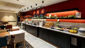 Een moderne hotelkeuken met een buffetopstelling, inclusief diverse etenswaren en een koffiehoek.