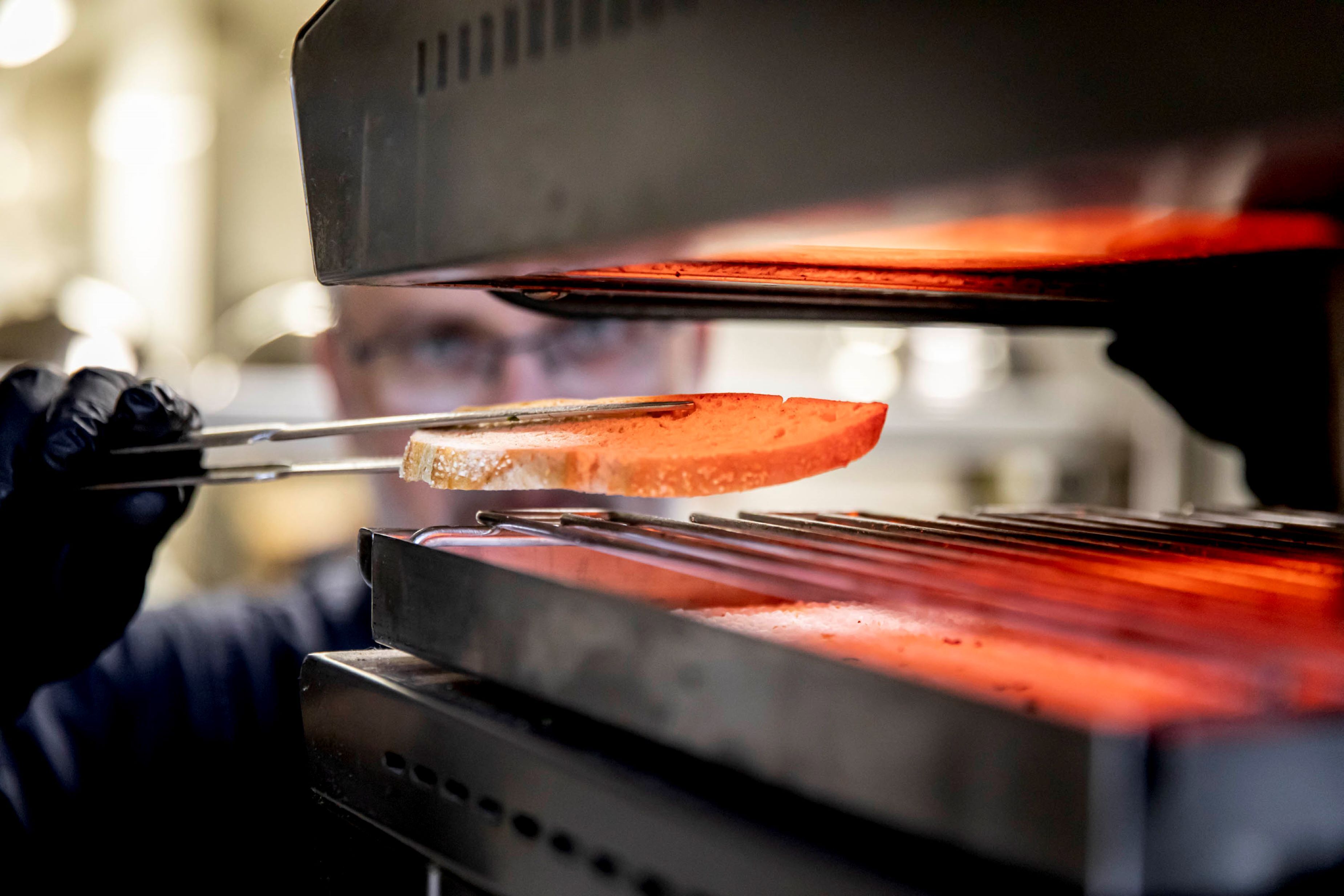 A close-up of a grill with a piece of meat being cooked.