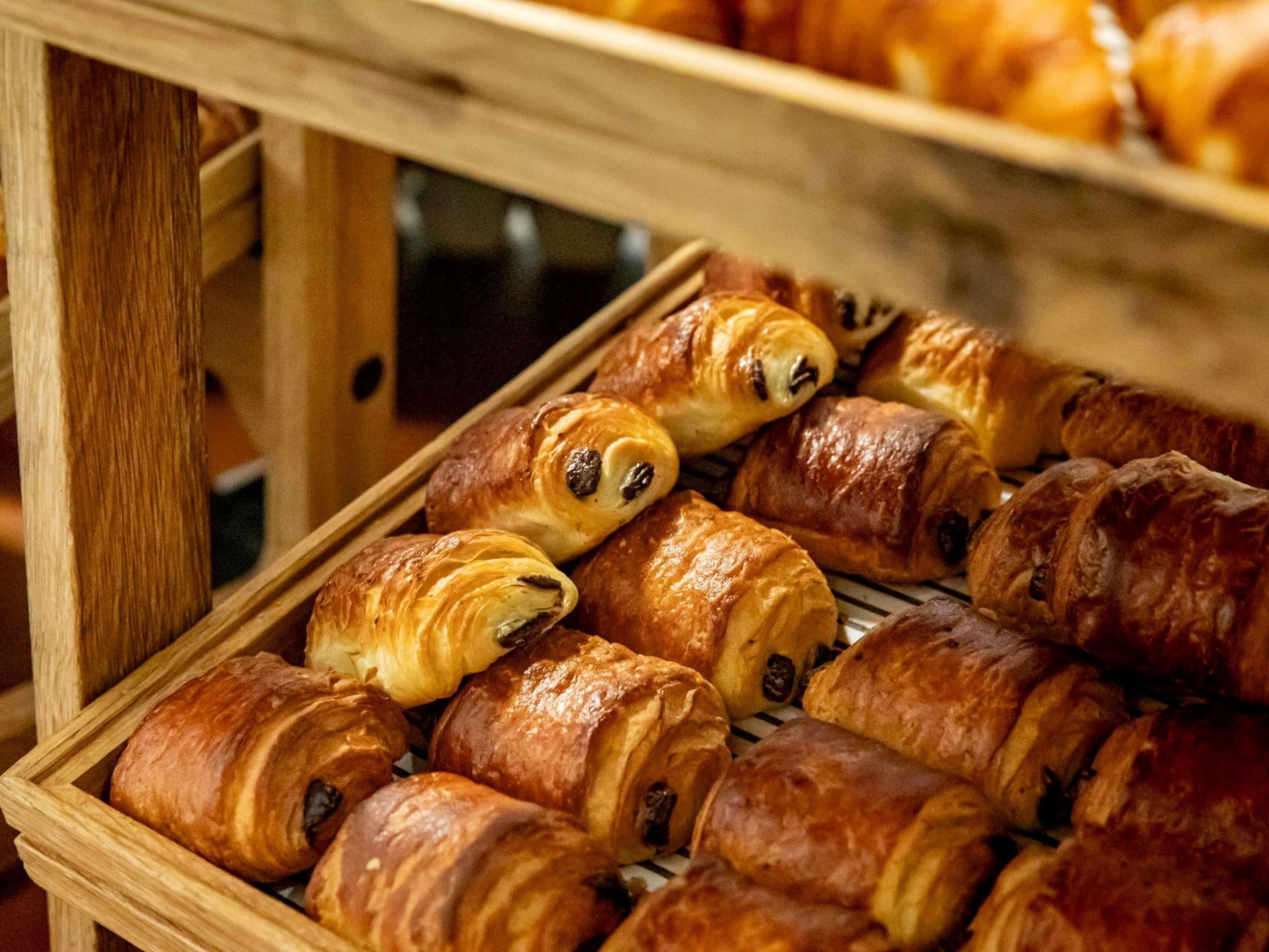 A display of assorted pastries in a wooden crate.