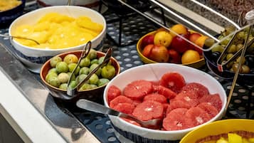 A buffet with various fruits including pineapple, grapes, and oranges.