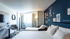 Una habitación de hotel con una cama grande, un escritorio, una silla y un televisor.