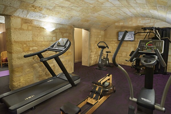 Un gimnasio con cintas de correr, una máquina de remo y una elíptica.