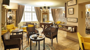 A hotel lobby with yellow chairs, a round table with a teapot, and framed pictures on the walls. - Best Western Premier Hotel Bayonne Etche Ona - Bordeaux (Bordeaux)