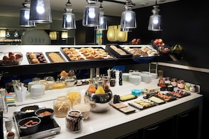 A buffet setup with various food items and condiments.