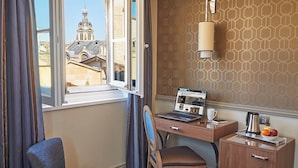 A hotel room with a bed, a desk with a laptop, a chair, a small table with a coffee pot and fruit, and a window with curtains. - Best Western Premier Hotel Bayonne Etche Ona - Bordeaux (Bordeaux)