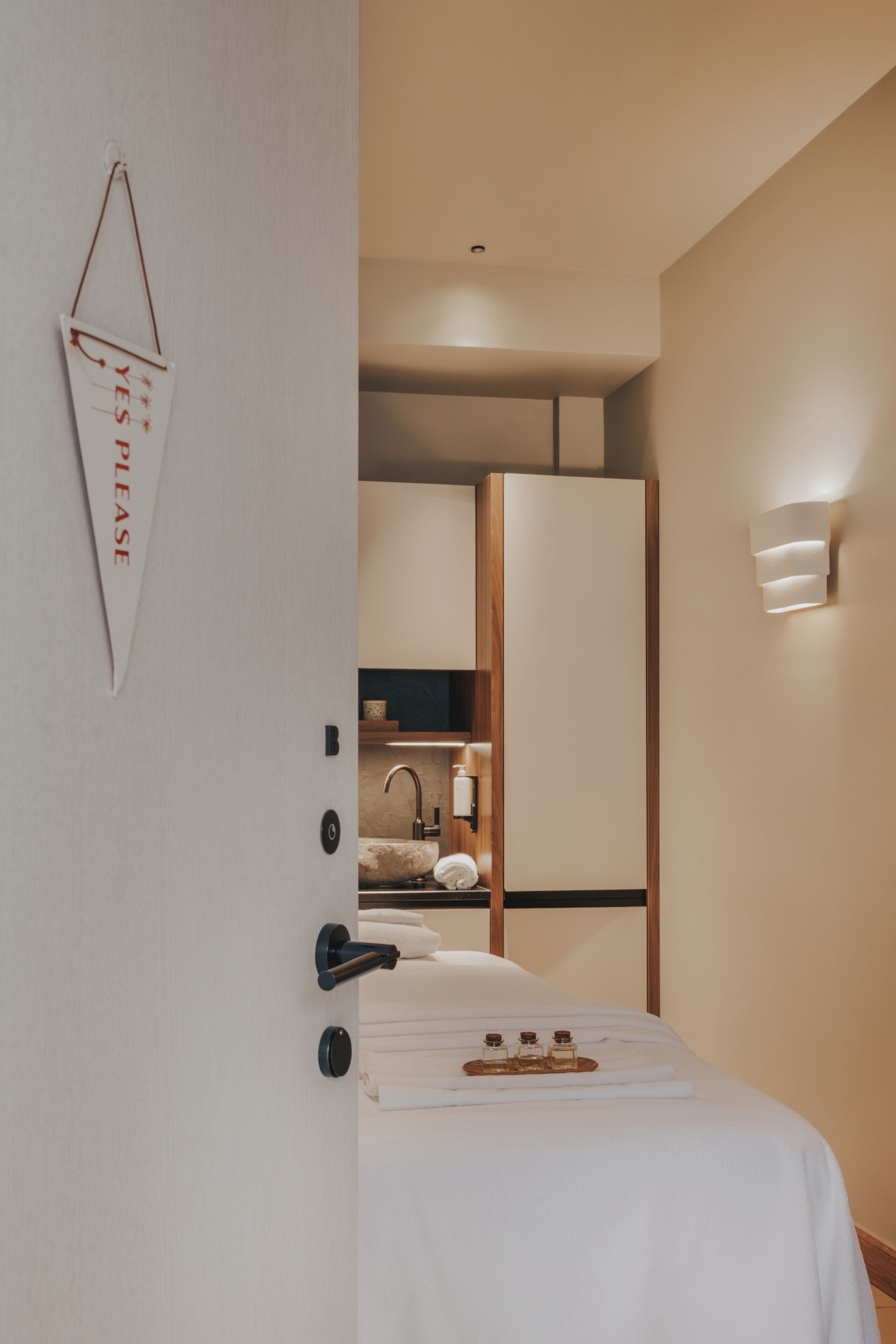 Une chambre d’hôtel moderne, équipée d’un lit, d’une salle de bain avec un lavabo et d’un miroir.