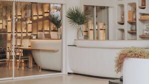 A modern interior with a curved ceiling, a central seating area, and a display of various items. - Hôtel & Spa Belle Plage (Cannes)