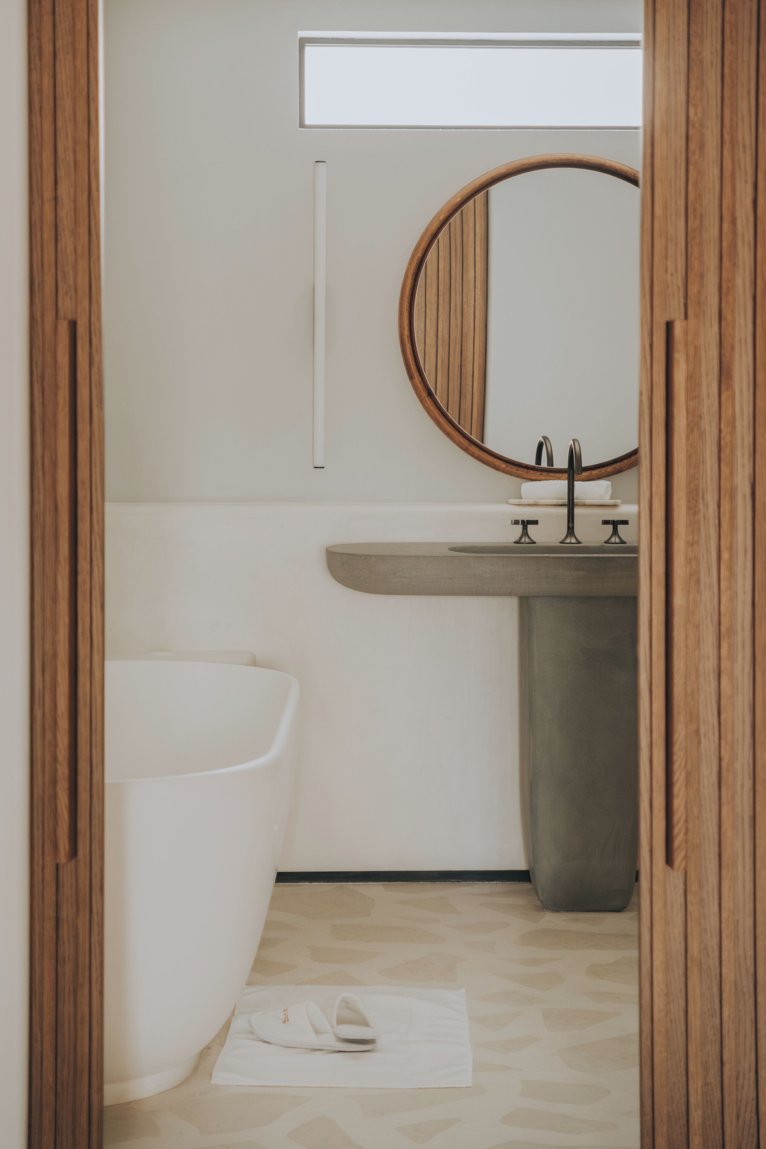 A bathroom with a bathtub, a sink, and a mirror.