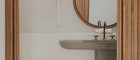 A bathroom with a bathtub, a sink, and a mirror.