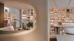 A modern interior with a central seating area, a dining space, and a large bathtub. - Hôtel & Spa Belle Plage (Cannes)
