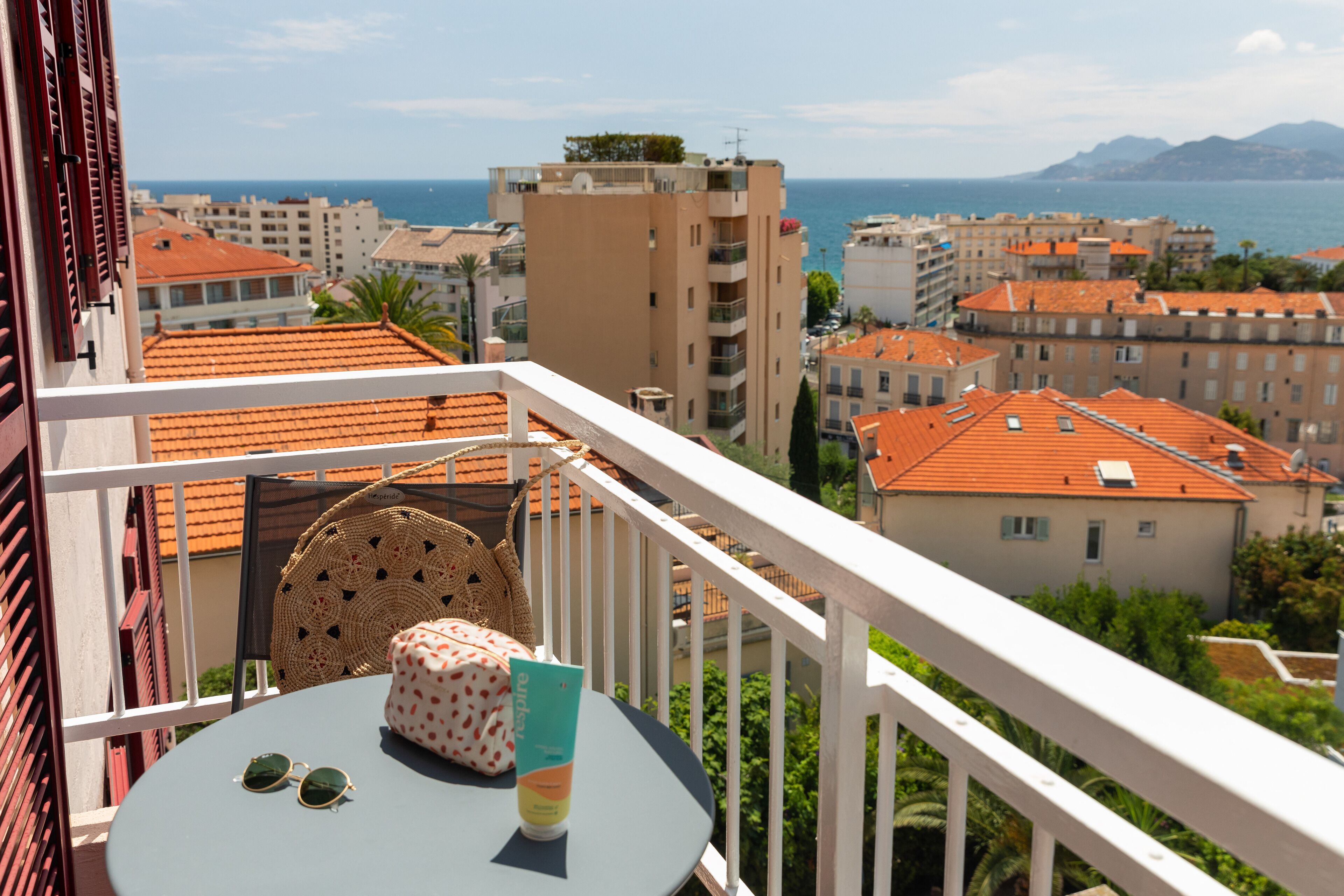Un balcon avec une table, un panier en osier et un sac à pois.