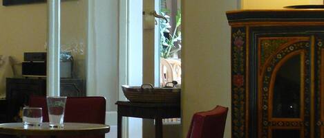 A dining area with a table and chairs, a clock on the wall, and a cabinet with a floral design.