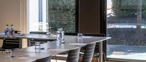 A conference room with a long table, chairs, and water bottles.