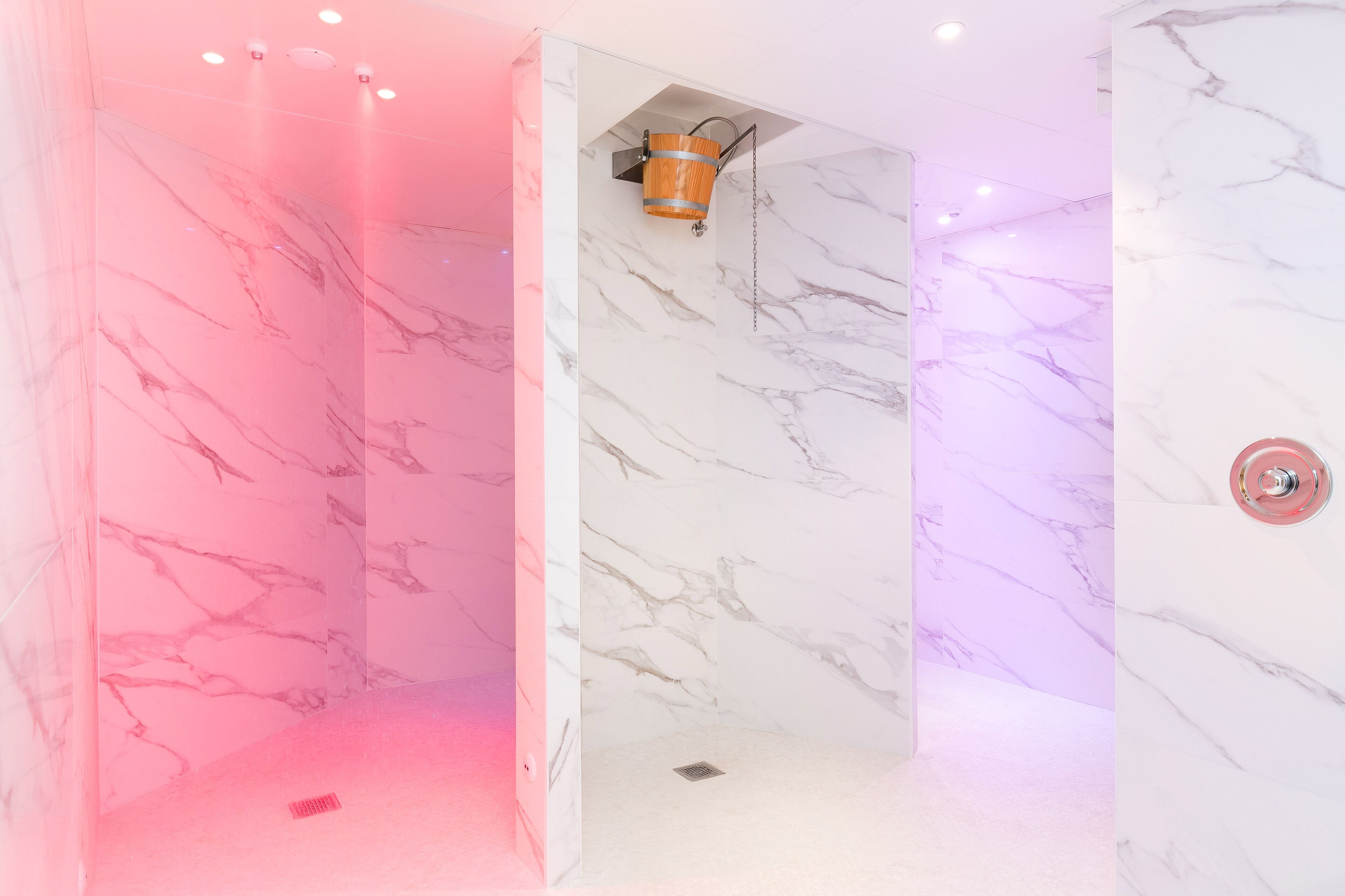 Un baño moderno con paredes de mármol y zona de ducha.