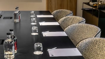 A conference table with documents, pens, and glassware.