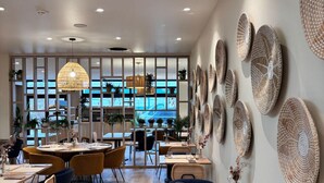 A modern restaurant interior with wooden flooring, round tables, and chairs. - 7Hotel&Spa (Illkirch-Graffenstaden)