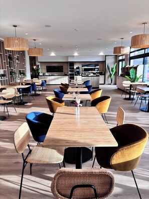 Enjoy meals in this stylish dining area with a central table, comfortable chairs, and a large TV screen.