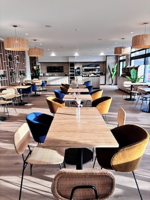 Enjoy meals in this stylish dining area with a central table, comfortable chairs, and a large TV screen.