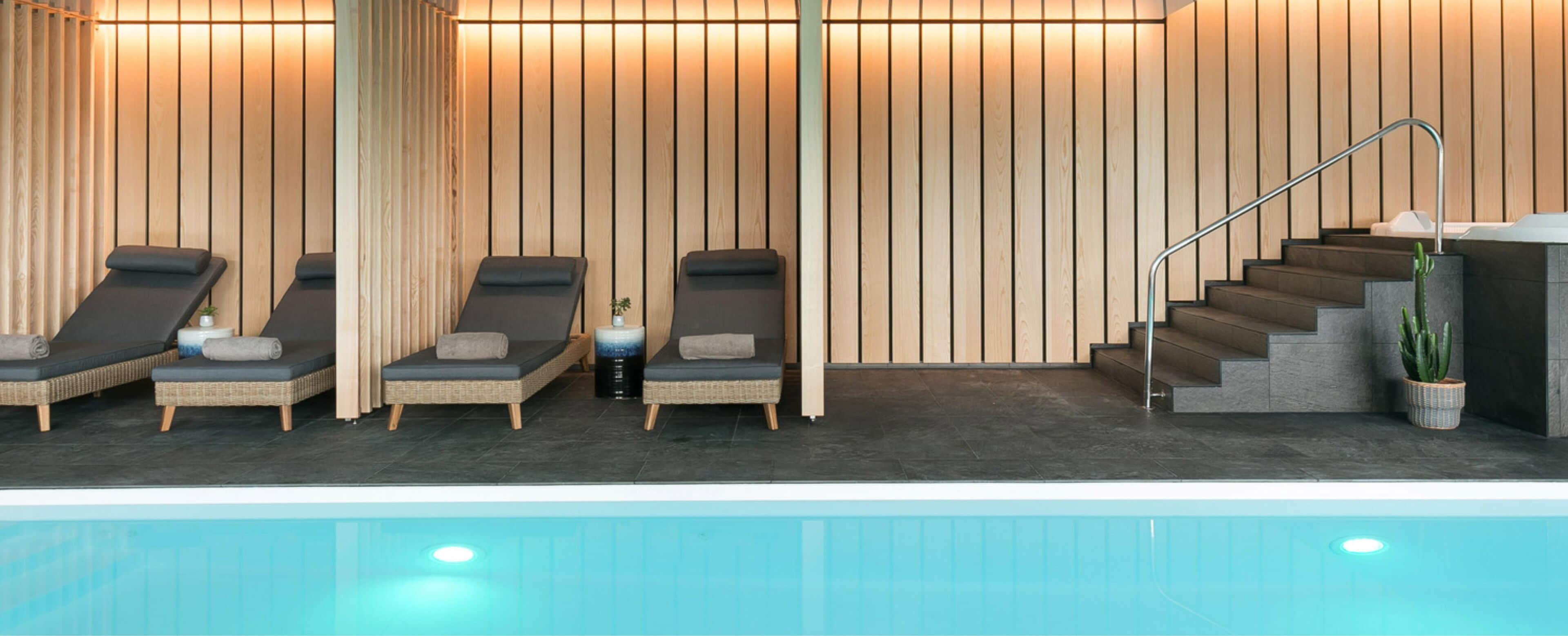 A spa area with a pool, wooden wall panels, and a staircase.