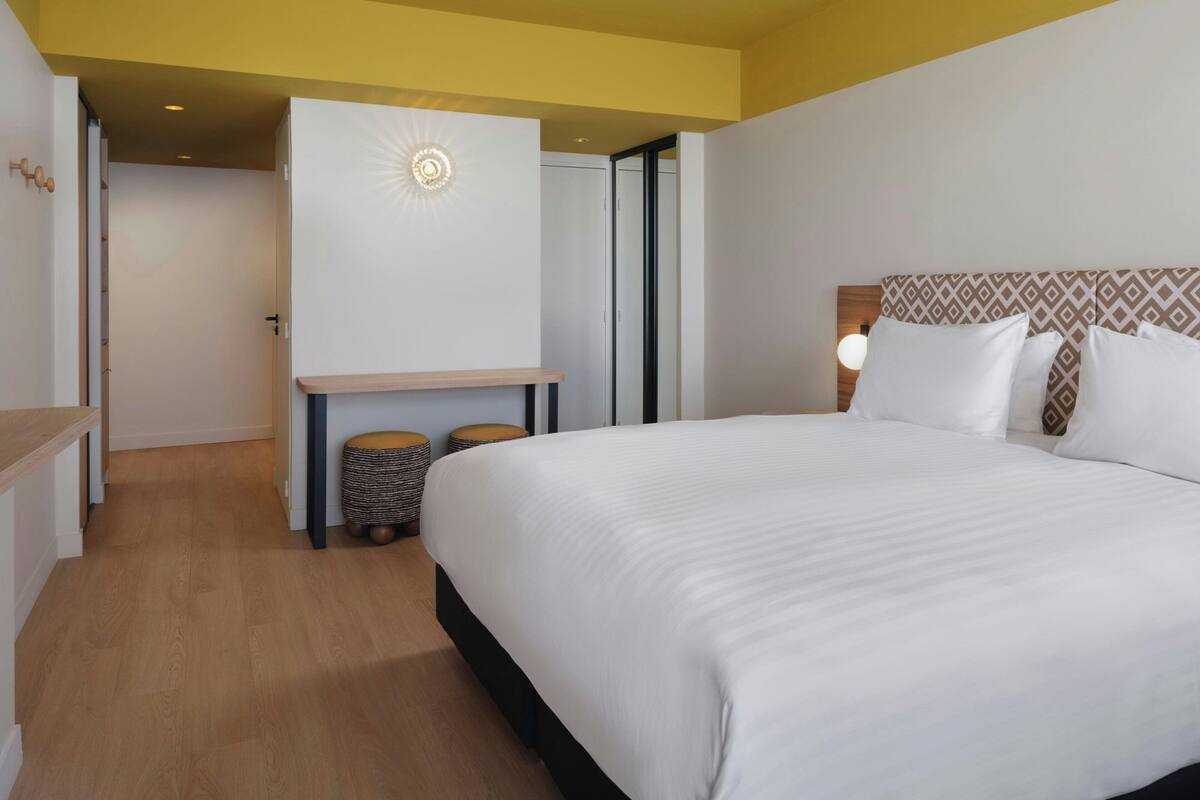 Una habitación de hotel con cama, escritorio y un pequeño rincón de descanso.