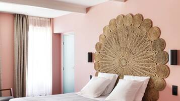 A bedroom with a large bed, a decorative wall headboard, a bedside table, and a view of a door.