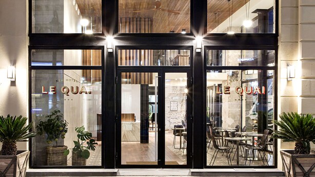 A hotel entrance with glass doors, interior seating, and visible signage. - New Hotel Le Quai - Vieux Port (Marseille)