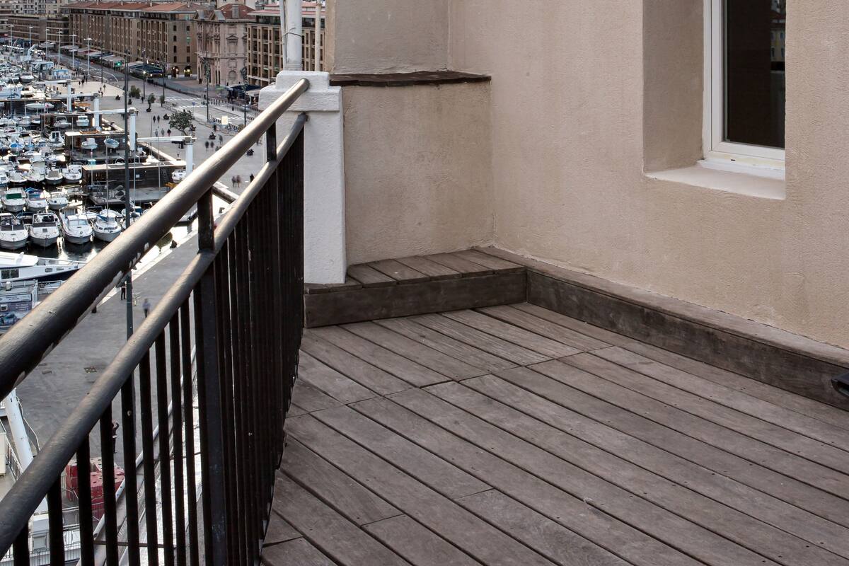 A balcony with a view of a marina and cityscape.
