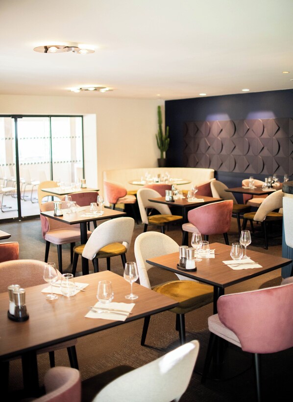 Un restaurante con mesas dispuestas para comer, sillas y un diseño de interiores moderno.