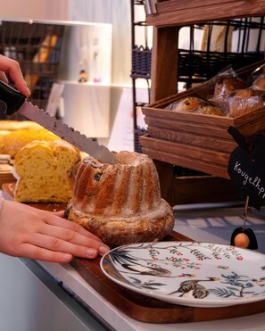 Una persona cortando un pastel bundt con un cuchillo.