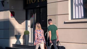 L’entrée d’un hôtel, avec une enseigne indiquant « HÔTEL ».