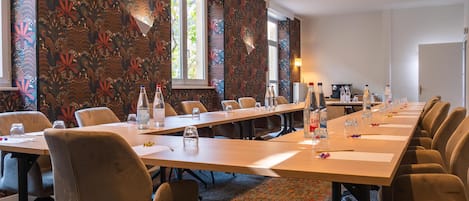 A conference room with a long table, chairs, and water bottles.