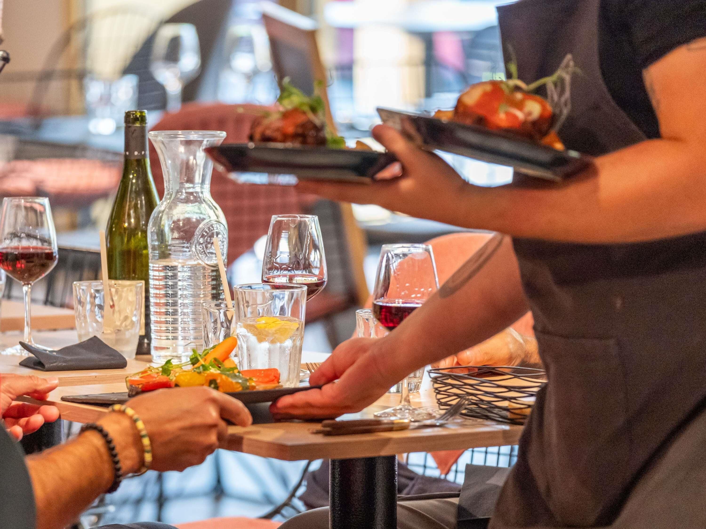 A dining table with various glasses, a bottle, and a plate with food.